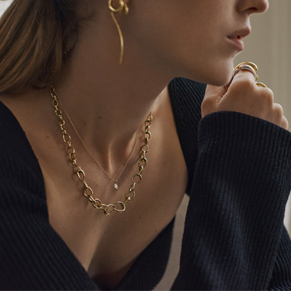 necklace, long earrings, swirl earring and pendant in 18 kt. yellow gold the mercy and Offspring collection in collaboration with Alexandria Carl for Art of Style campaign by Georg Jensen