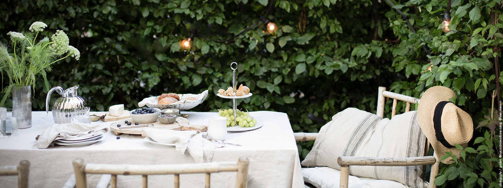 Table setting items from Georg Jensen displayed on an outdoor table