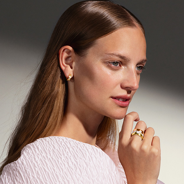 rings and small earhoops in 18-karat yellow, rose and white gold with diamonds on model with dress from the Fusion collection created by Nina Koppel for Georg Jensen