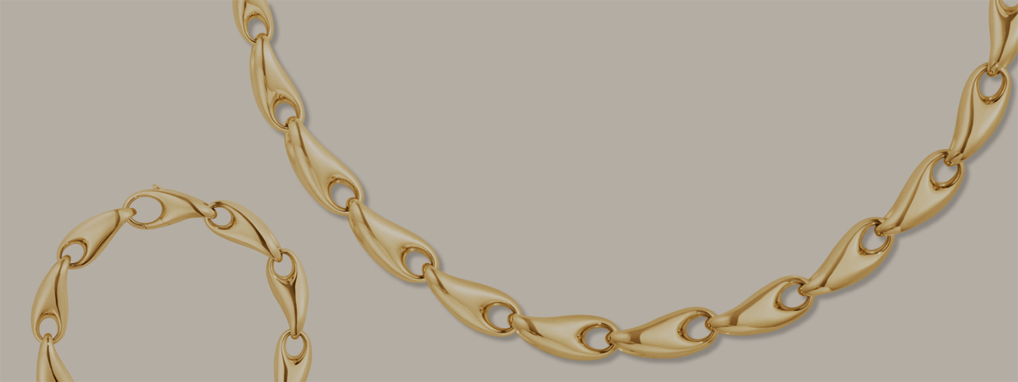 chain necklace and bracelet in 18 karat yellow gold from the reflect collection designed by jacquelin rabun on beige background
