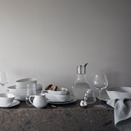 White porcelain plates and bowls and crystal clear wine and water glasses from the Sky collection