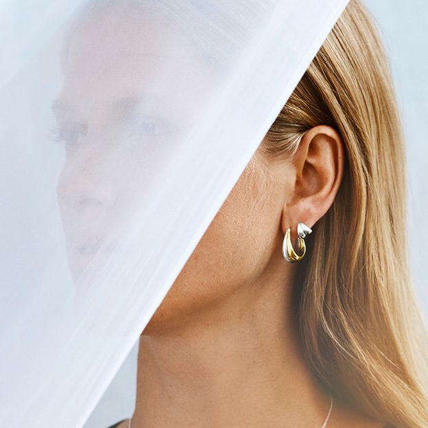 Sterling silver and 19 kt. god earrings on model from the Curve collection