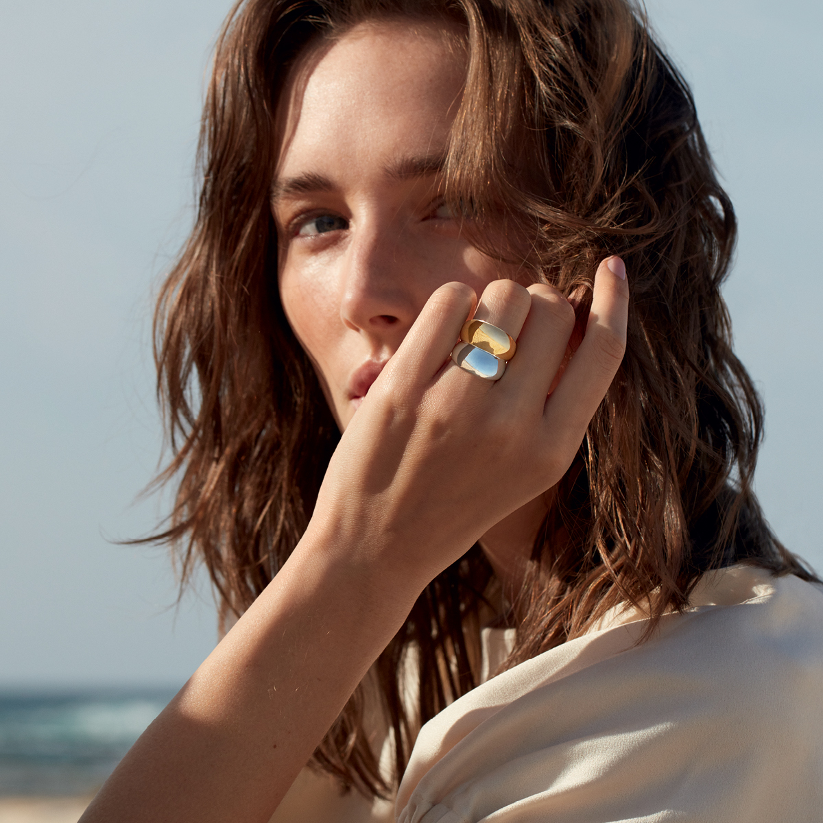 A photo of model wearing sterling silver and 18kt. Yellow gold ring from Georg Jensen Curve collection