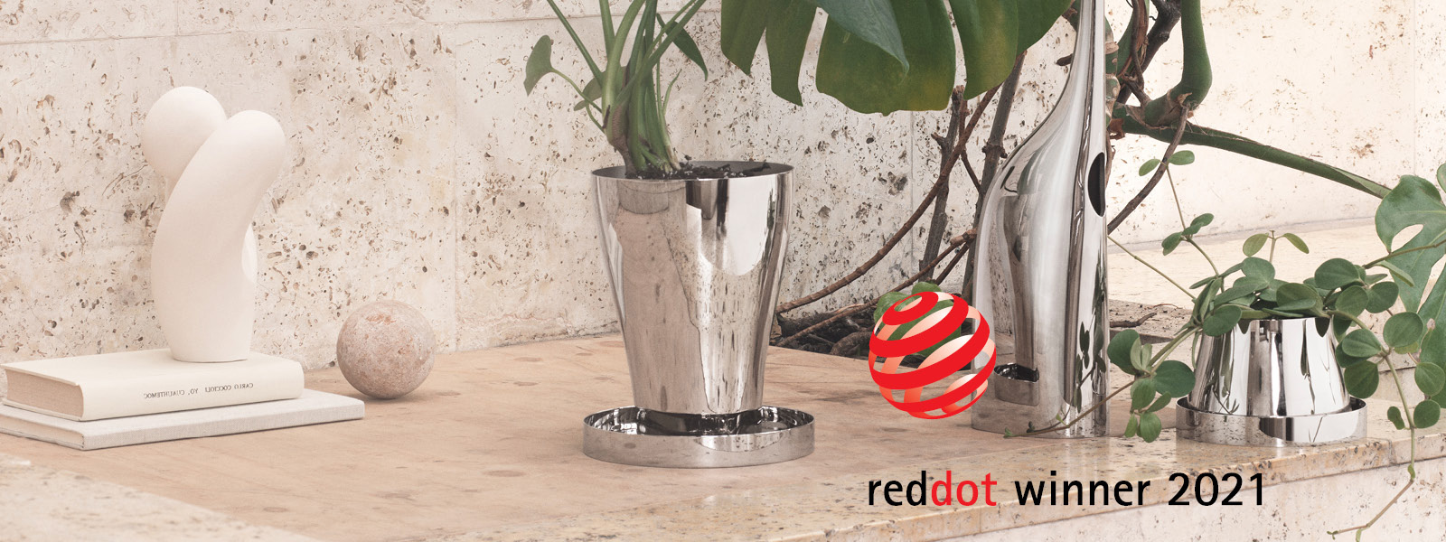 Red Dot 2021 award winning Mirror polished stainless steel watering can and terracotta planter from the Terra collection designed by Georg Jensen and Snøhetta