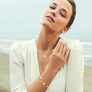On model image featuring 18 kt. gold plated and white enamel Daisy flower from the Daisy collection by Georg Jensen