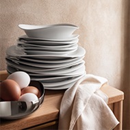 Mirror polished stainless steel bowl and ceramic plates from the Cobra collection