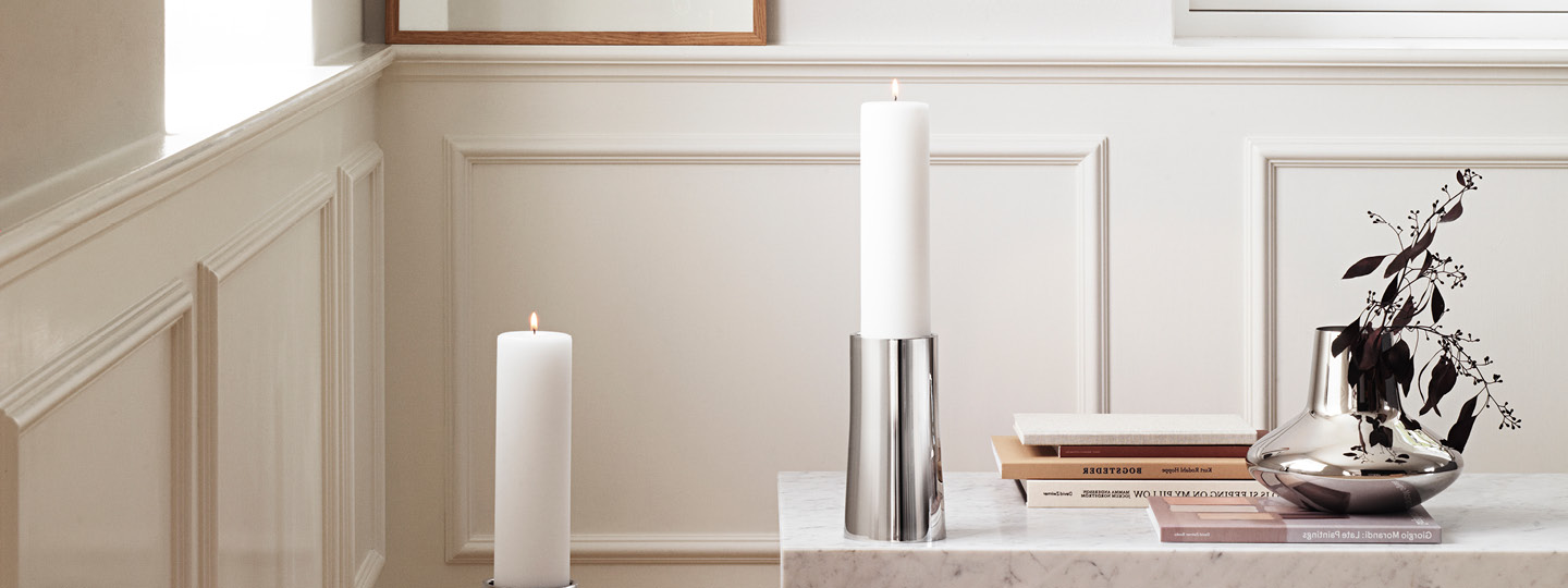 Ambience Candle Holders in mirror polished stainless steel in small. Koppel Vase in mirror polished stainless steel.