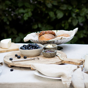 Tableware from the Bernadotte collection by Georg Jensen displayed on an outdoor breakfast table