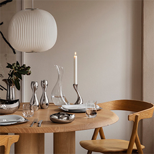 Mirror polished stainless steel salt and pepper, candleholder and porcelain plates tablesetting from the Cobra collection