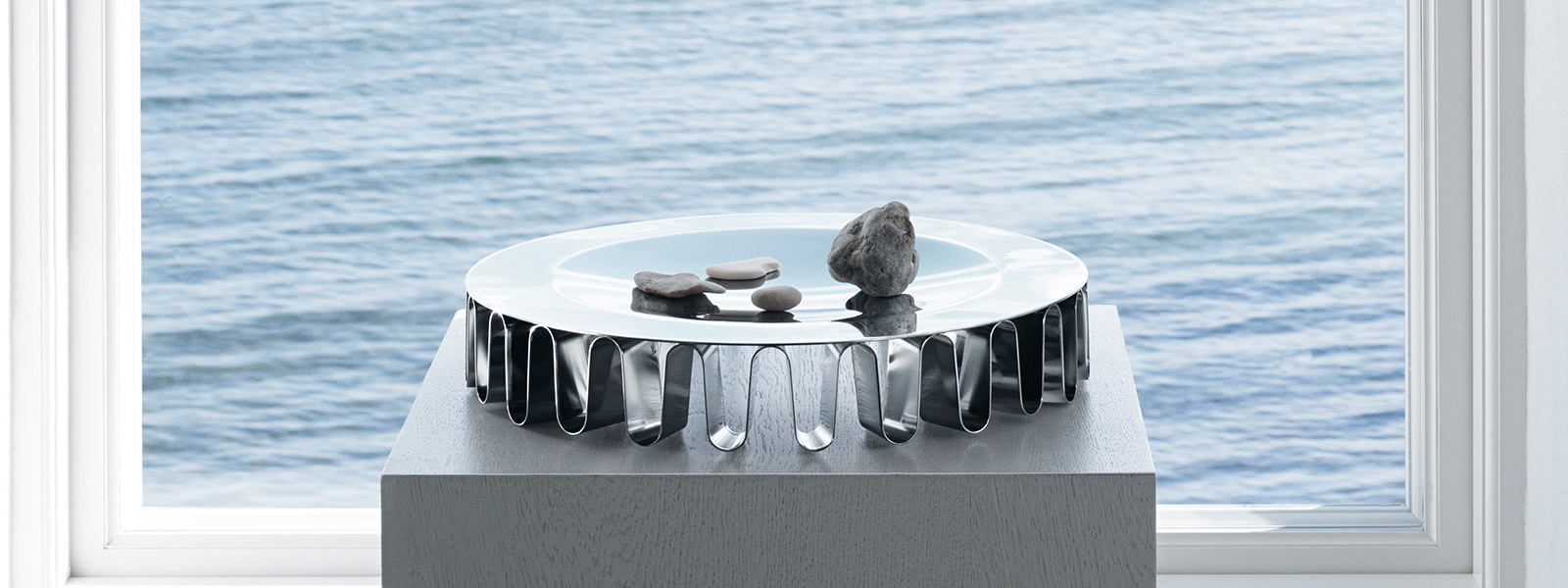 Scandinavian design house Georg Jensen home decor mirror polished stainless steel centrepiece with sea in background