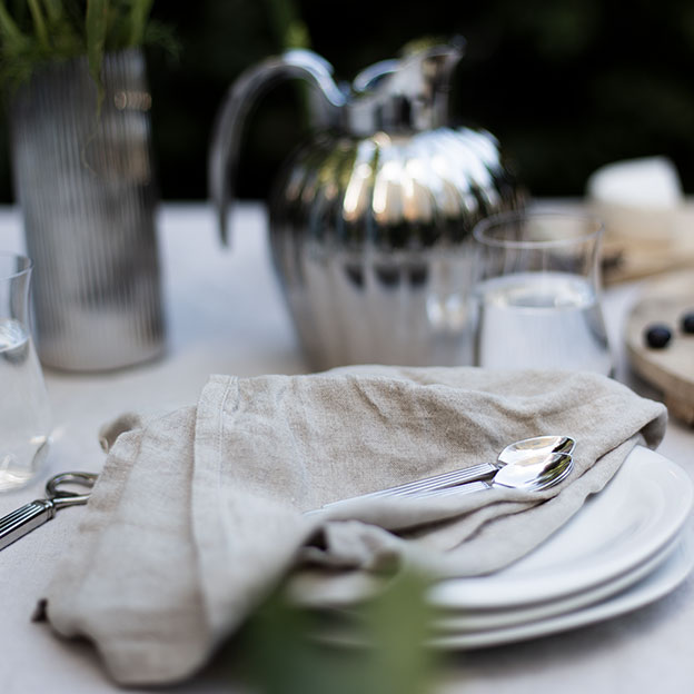 Georg Jensen outdoor tablesetting with Cobra plates, Bernadotte cutlery, vase and thermo in polished stainless steel