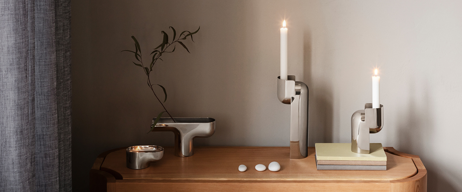 Vases and candlholdres in mirror polished stainless steel and silver and designed by Tokyo based studio Nendo