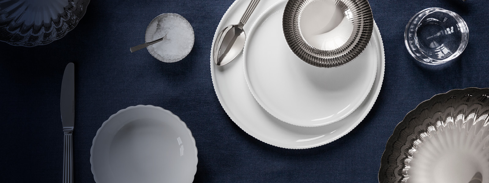 Porcelain plates and mirror polished stainless steel cutlery and bowl from the Bernadotte collection by Sigvard Bernadotte