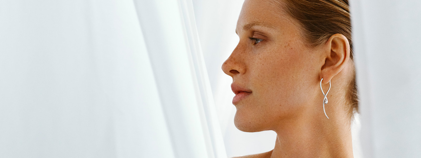 Silver earring from the Mercy collection on a model for Christmas gift inspiration for women designed by Georg Jensen