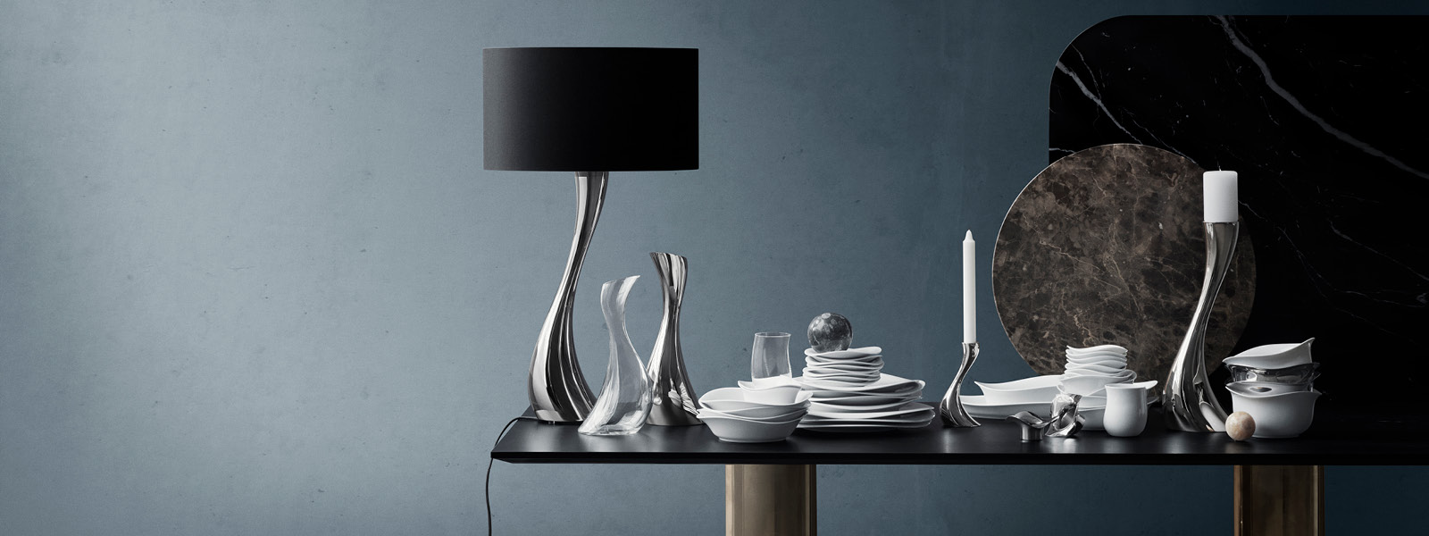Crystal clear glass carafe and glasses with mirror polished stainless steel candle holders and lamp